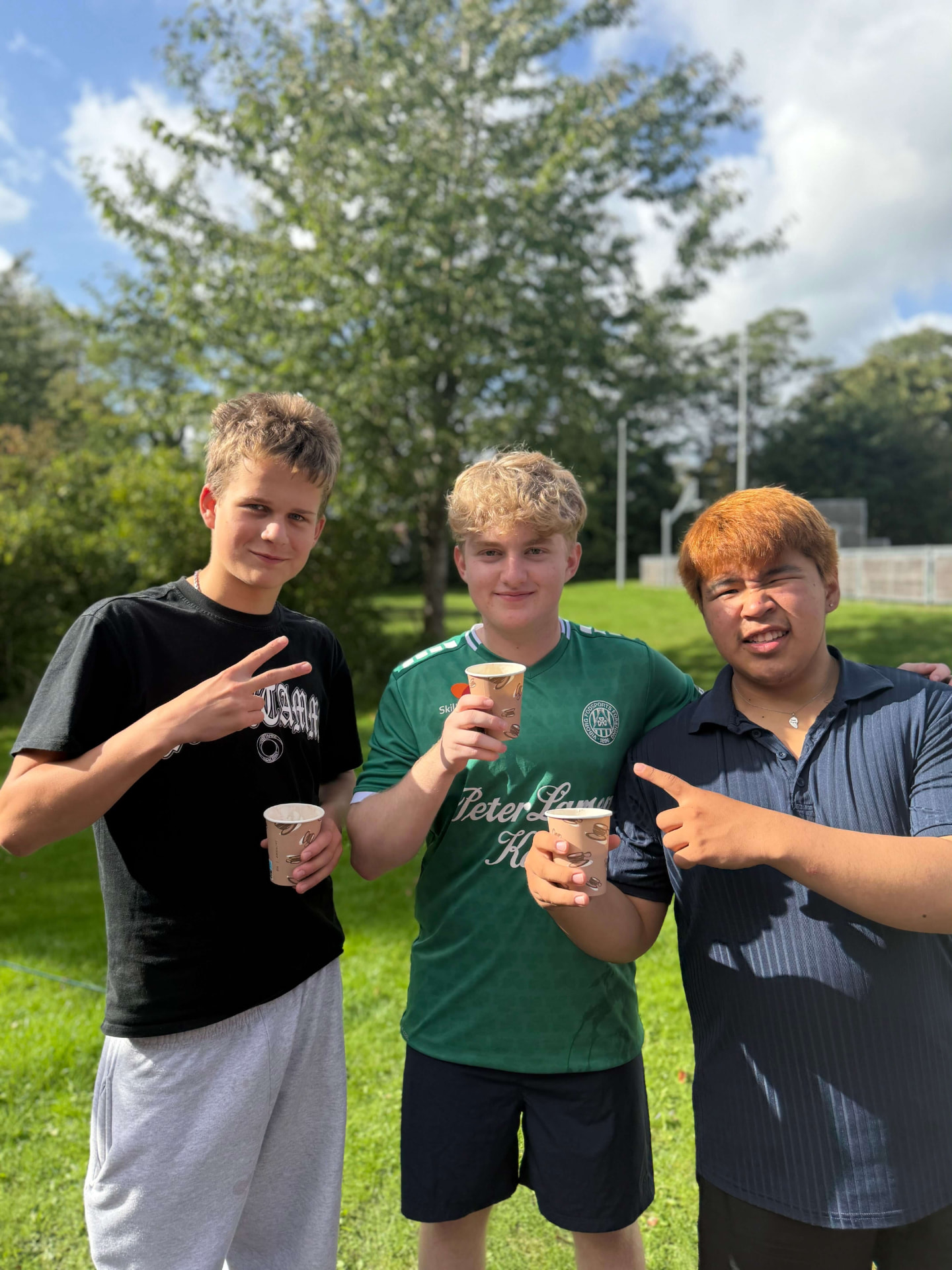 Tre elever med varm kakao i skolens have