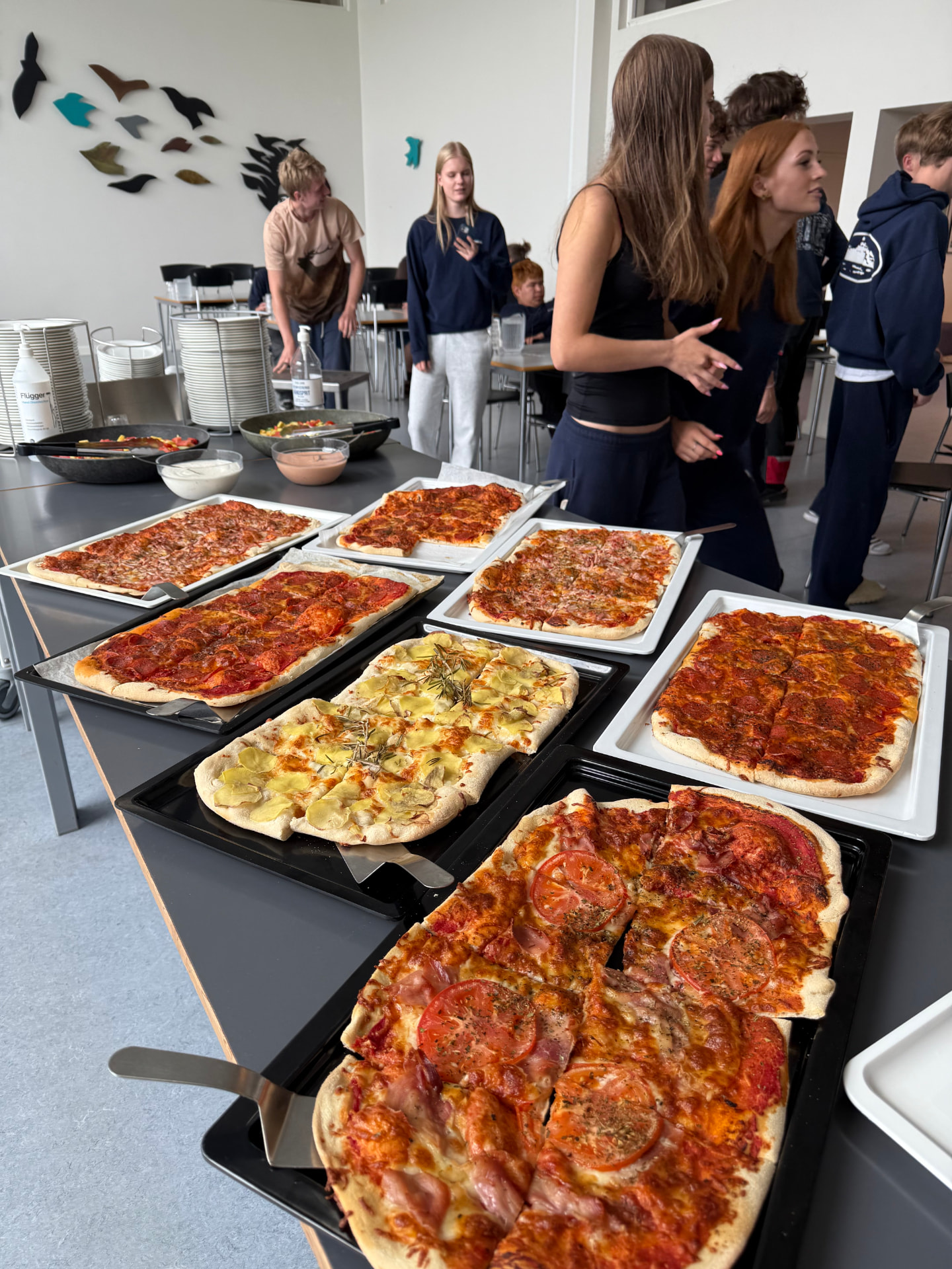 Elever henter hjemmelavet pizza i spisesalen på Nørbæk Efterskole