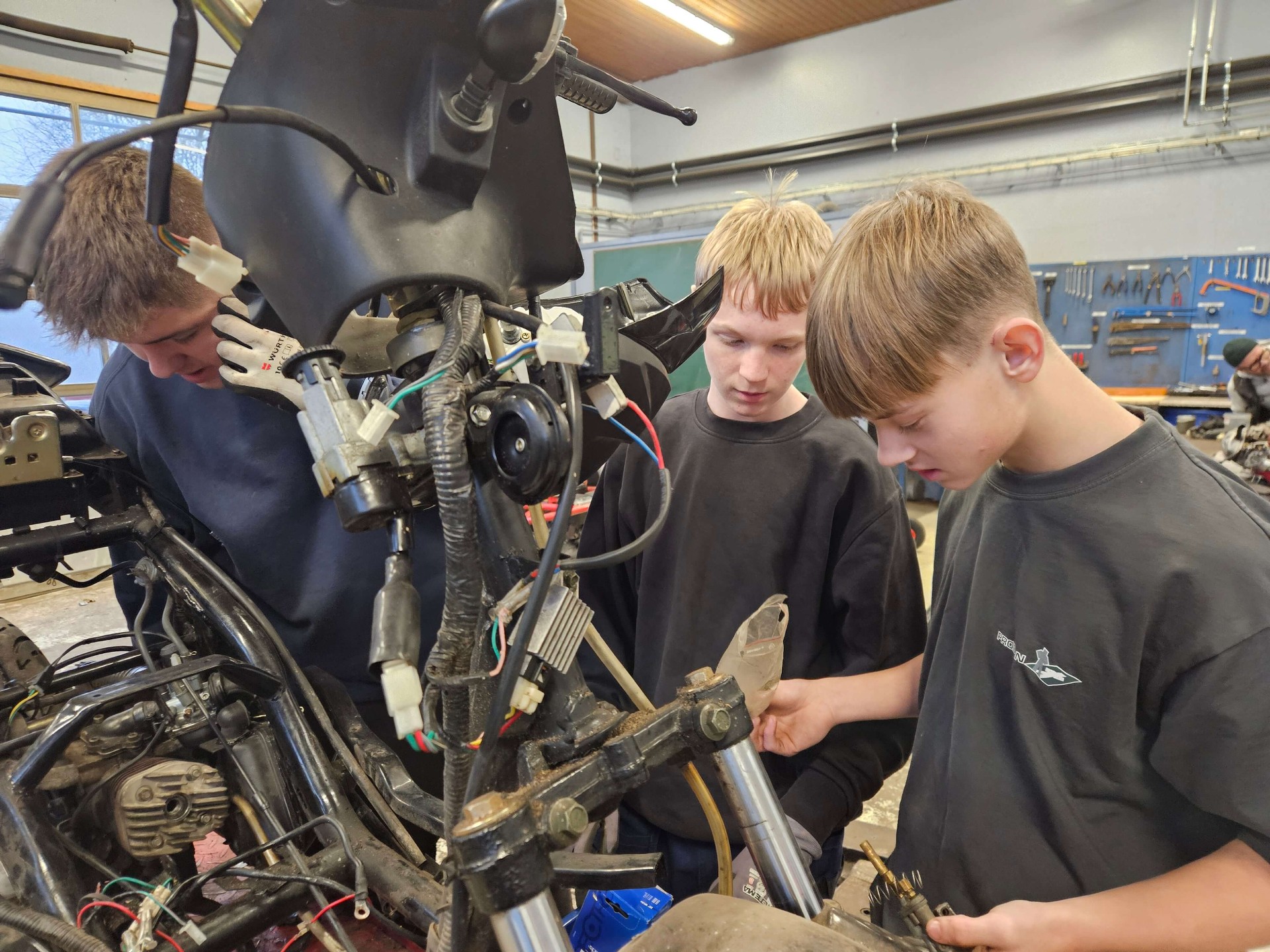 Elever arbejder med motorlære i værkstedet på Nørbæk Efterskole