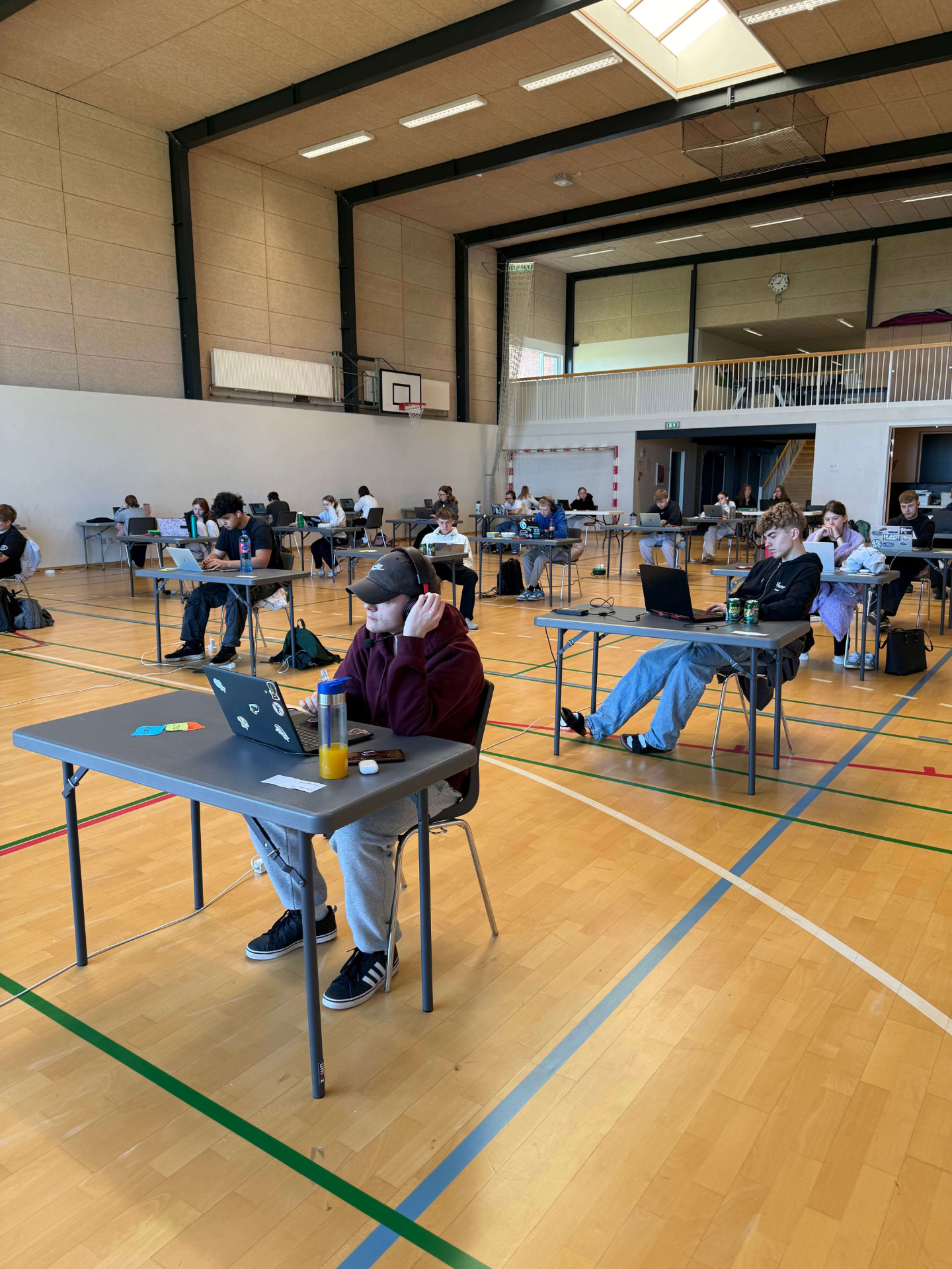 Elever til afgangsprøve med computere i hallen på Nørbæk Efterskole