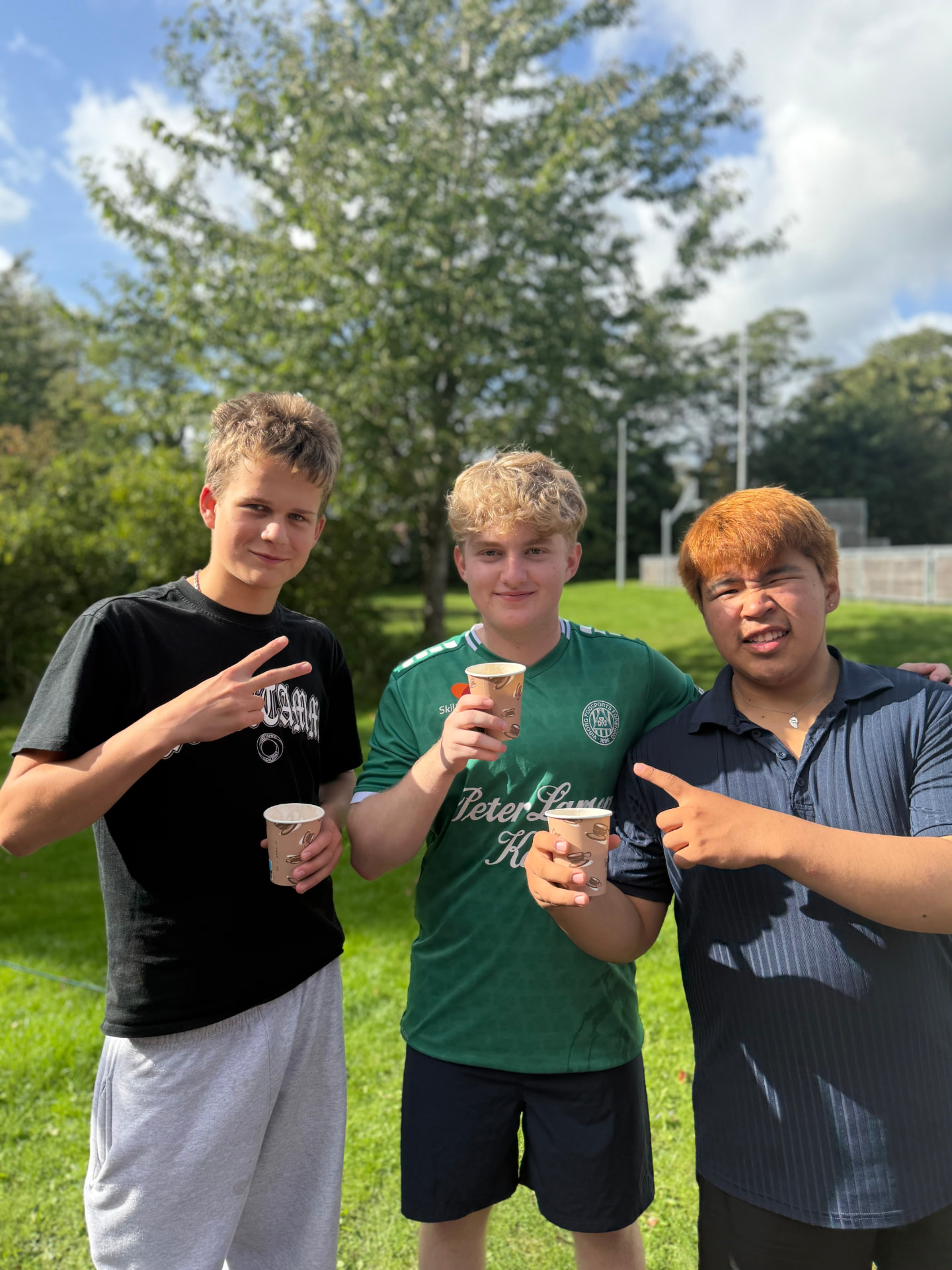 Tre elever med kakao udenfor