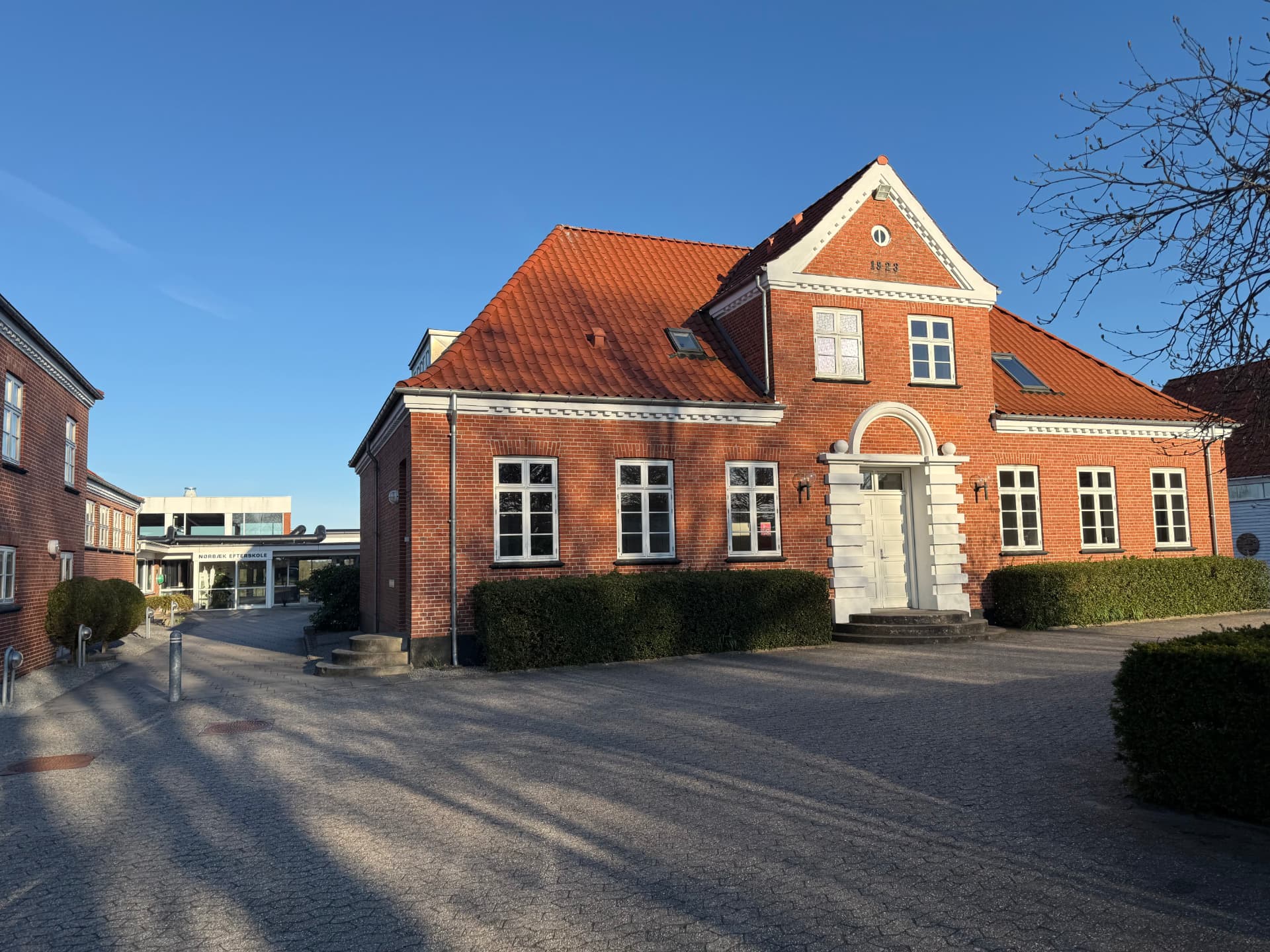 Nørbæk Efterskoles hovedbygning i røde mursten en solskinsdag